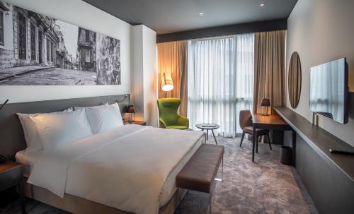 um quarto de hotel com uma cama e uma secretária em CUE Podgorica em Podgorica
