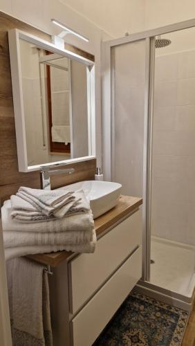 a bathroom with a sink and a mirror and a shower at Bandìtella home in Livorno