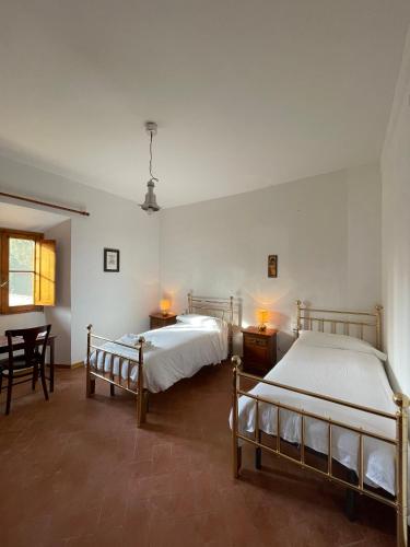 a bedroom with two beds and a table and chairs at Casa per la Pace in Impruneta