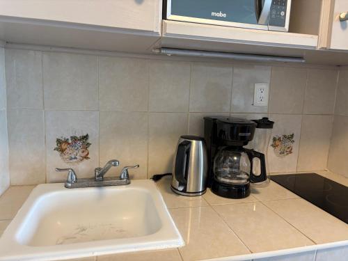 a kitchen counter with a sink and a coffee maker at Solymar Zona Hotelera Cancún in Cancún
