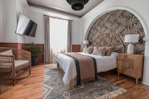 a bedroom with a large bed and a chair at Lofts Álvaro Obregón in Mexico City
