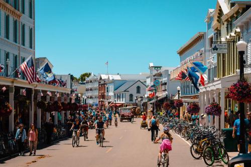 a crowd of people riding bikes down a street at Above Mustang Condos in Mackinac Island