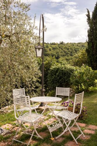 a table and two chairs with a table and a lamp at Agriturismo La Romagnana in Pistoia