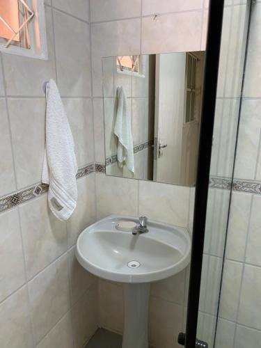a bathroom with a sink and a mirror at Chalés no Quintal in Alvorada do Sul