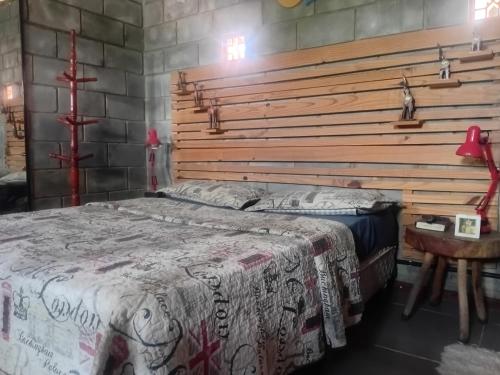 a bedroom with a bed with a wooden headboard at Villa Madalena Lofts in Maceió