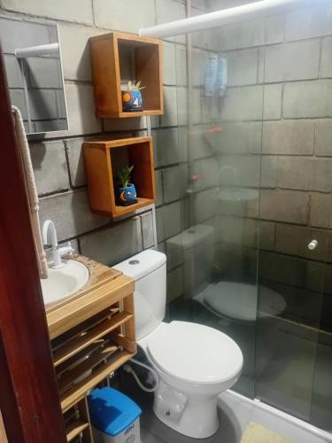 a bathroom with a toilet and a sink and a shower at Villa Madalena Lofts in Maceió