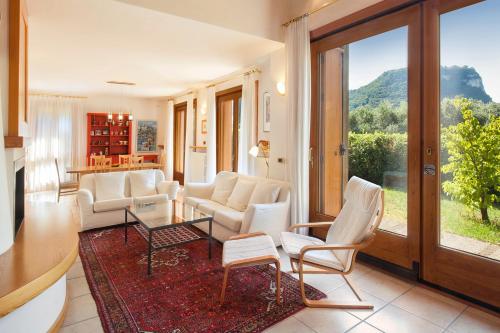 a living room with white chairs and a table at Casa Flora in Garda