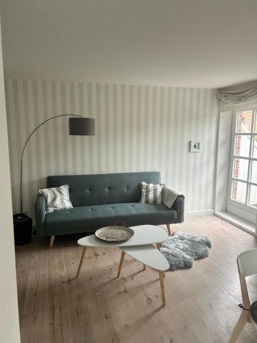 a living room with a blue couch and a table at Linn in Oldsum