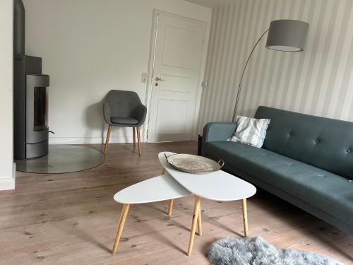 a living room with a green couch and a table at Linn in Oldsum