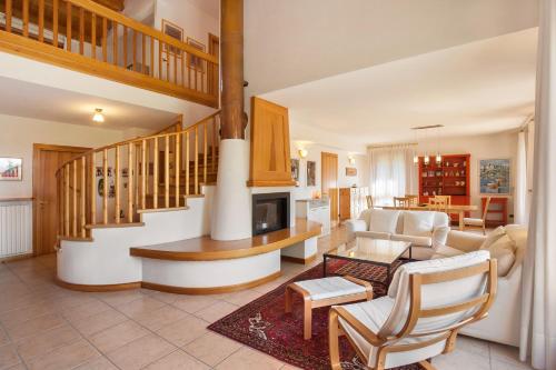 a living room with a staircase and a couch and a table at Casa Flora in Garda