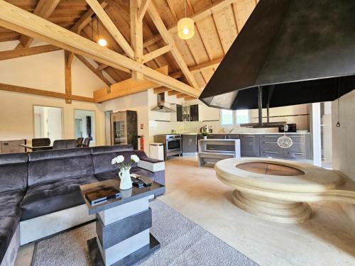 a large living room with a couch and a kitchen at Gîte familial à Jezainville - Nature, terrasses & jardin clos, Vue vallée, forêt in Jezainville