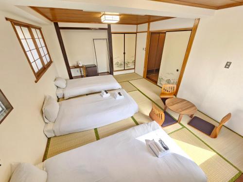 a room with two beds and a table at Tourist Hotel New Aoki 観光ホテル ニュー青木 in Tokyo
