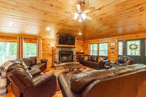 a living room with leather furniture and a fireplace at Cozy Cabin by Railey Vacations in Oakland
