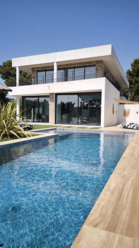 Cassis Lodges في كاسيس: منزل به حوض سباحة أمام المنزل