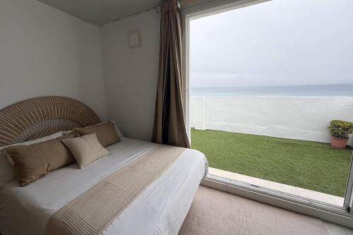 a bedroom with a bed and a large window at Ed.Senses. Apto Infinity in Tarifa