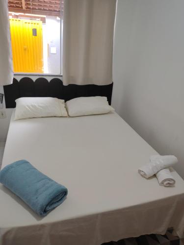 a large white bed with a blue towel on it at Aconchego e tranquilidade é aqui!!!! Te aguardo! in Porto Seguro