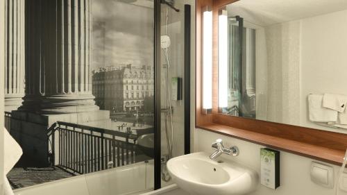 a bathroom with a sink and a window with a view at Campanile NATURE - Saint-Germain-en-Laye in Saint-Germain-en-Laye