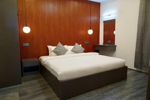 a bedroom with a large bed with a red wall at Sea Tides Dhangethi in Dhangethi