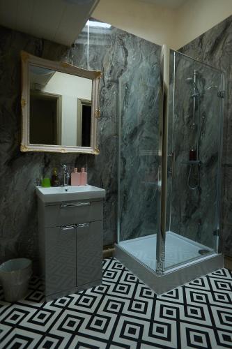 a bathroom with a shower and a sink and a mirror at The Forester and Flower in Bath