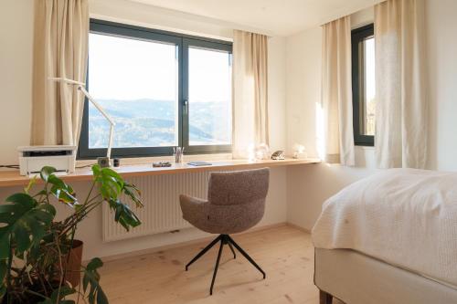 a bedroom with a bed and a chair and a window at Almhaus Kloster 38 in Kloster