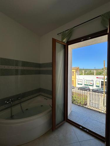 a bath tub in a bathroom with a sliding glass door at La Casa del Corso in Bari Sardo
