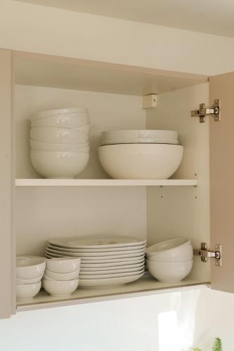 a cabinet filled with white bowls and plates at Almhaus Kloster 38 in Kloster
