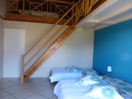two beds in a room with blue walls at Chez Sandrine in Cilaos