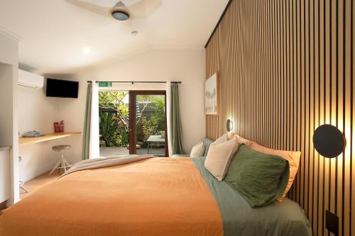 a bedroom with a bed and a sliding glass door at Alcorn Garden Studio - Dog friendly 2 mins walk to beach in Suffolk Park