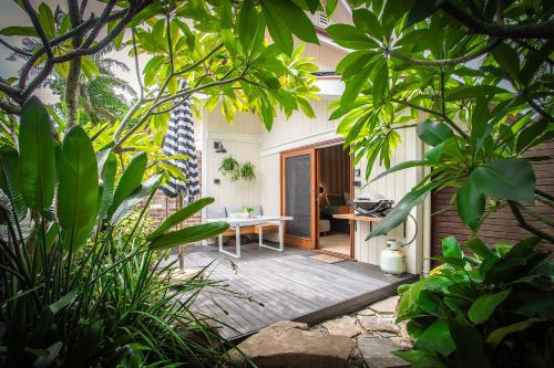 a room with a table in the middle of a garden at Alcorn Garden Studio - Dog friendly 2 mins walk to beach in Suffolk Park