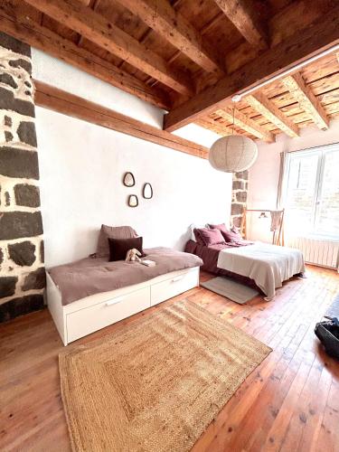 a bedroom with two beds and a rug at Maison atypique - Au coeur de la vieille ville in Le Puy-en-Velay