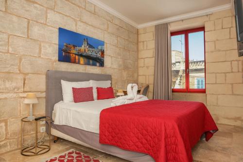 a bedroom with a bed with a red blanket at Palazzo Pisani & Spa Malta in Żabbar