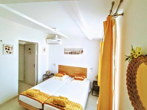 a bedroom with a bed and a yellow curtain at Villa les volets bleus in Le Grau-dʼAgde