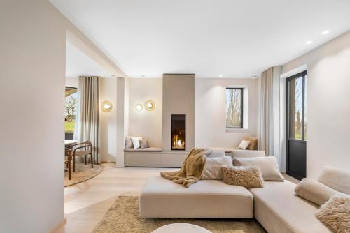 a living room with a white couch and a fireplace at De Kompanie in Alken
