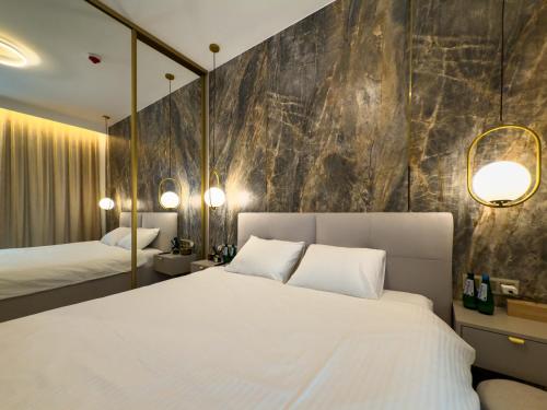 a bedroom with a large white bed and a stone wall at VIDOK Apartament Olsztyn Premium 204 in Olsztyn