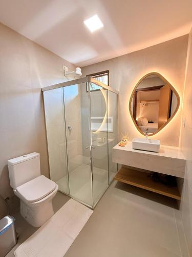 a bathroom with a shower and a toilet and a mirror at Nari Guest Room in Fernando de Noronha