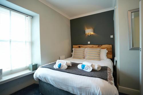 a bedroom with a bed with towels on it at Arosfa Harbourside Aberaeron in Aberaeron
