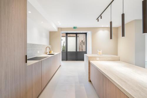 a kitchen with a long counter and a hallway at De Kompanie in Alken