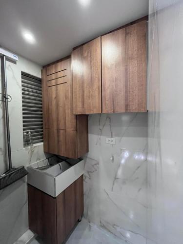 a bathroom with a sink and wooden cabinets at El lujo y la comodidad in Zipaquirá