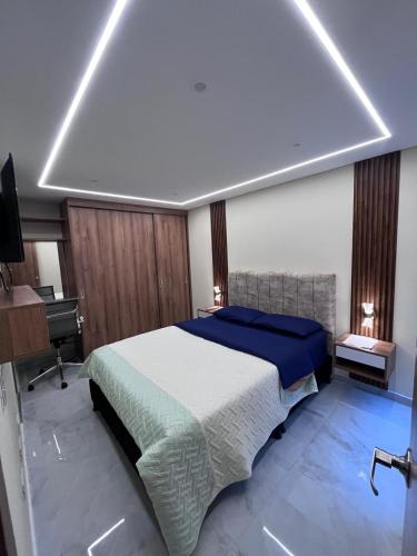 a bedroom with a large bed and a desk at El lujo y la comodidad in Zipaquirá