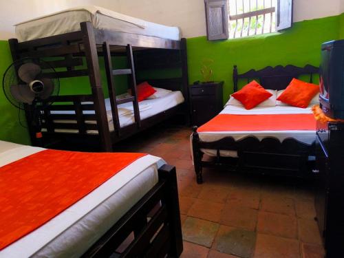 a bedroom with two bunk beds with green walls at Hostal Villa Cecilia in Villavieja