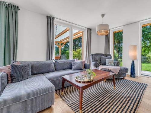 a living room with a couch and a table at Haus am Seeufer mit Badestelle in 200m, große Sonnenterrasse, umzäunter Garten, Hunde willkommen in Rheinsberg