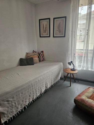 a white bedroom with a bed and a table at Depto arlegui centro in Viña del Mar
