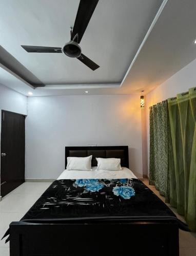 a bedroom with a bed with a ceiling fan at The Retreat Base in Rājpur