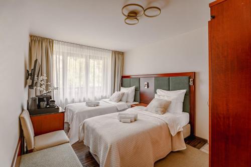 a hotel room with two beds and a chair at Willa RIVA in Wisła