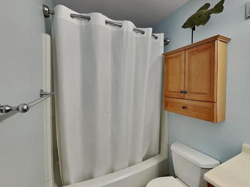 a bathroom with a shower curtain and a toilet at Lighthouse Point 11C in Tybee Island