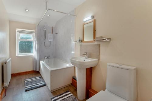 a bathroom with a sink and a toilet and a tub at 3 Bed in Littledean oc-g31084 in Little Dean