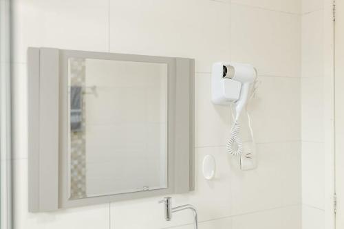 a bathroom with a mirror and a hairdryer at Casa Aconchego da Bisa - perto do Estádio do Operário! in Ponta Grossa