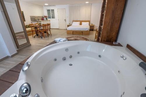 a bath tub in a room with a bedroom at Nesbehadnes in Had Nes