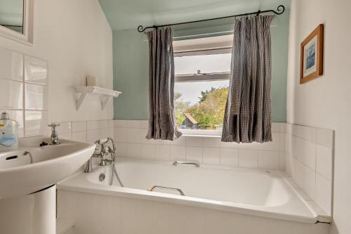 a white bathroom with a tub and a sink at 2 Bed in Walberswick oc-h29096 in Walberswick