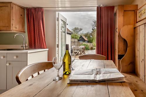 a wooden table with a bottle of wine and a glass at 2 Bed in Walberswick oc-h29096 in Walberswick